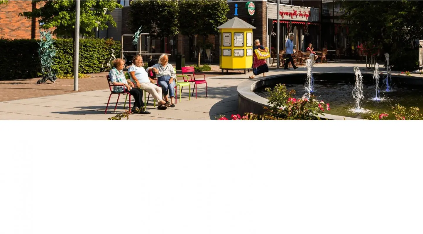 Foto van 3 bewoners die op het Theaterplein in De Hogeweyk in Weesp zitten